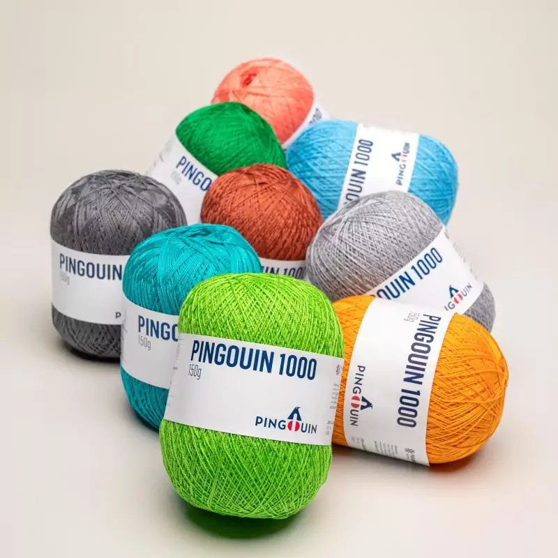 Novelos Pingouin 1000 em diversas cores (verde-limão, teal, azul, laranja, coral) com rótulo do pinguim